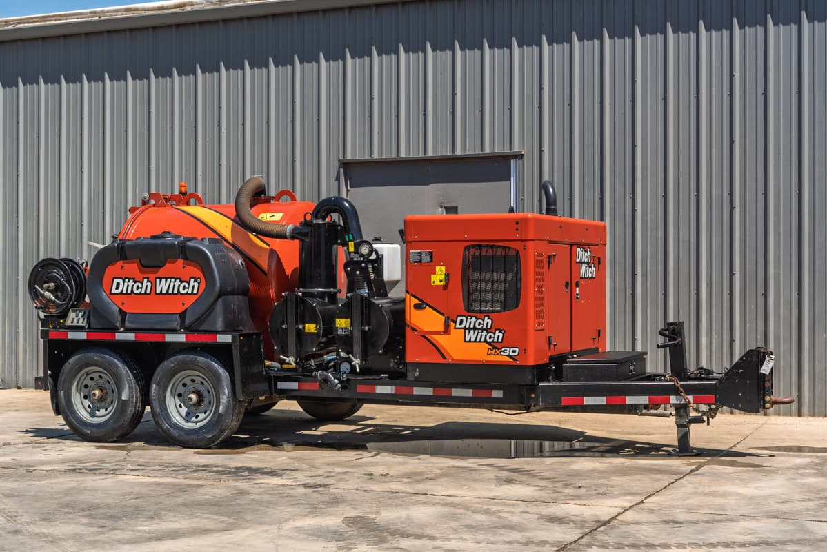 2023 Ditch Witch HX30 mud recycler, trailer-mounted, 3/4 rear view, orange vacuum tank, hose reel, engine enclosure, tandem axle