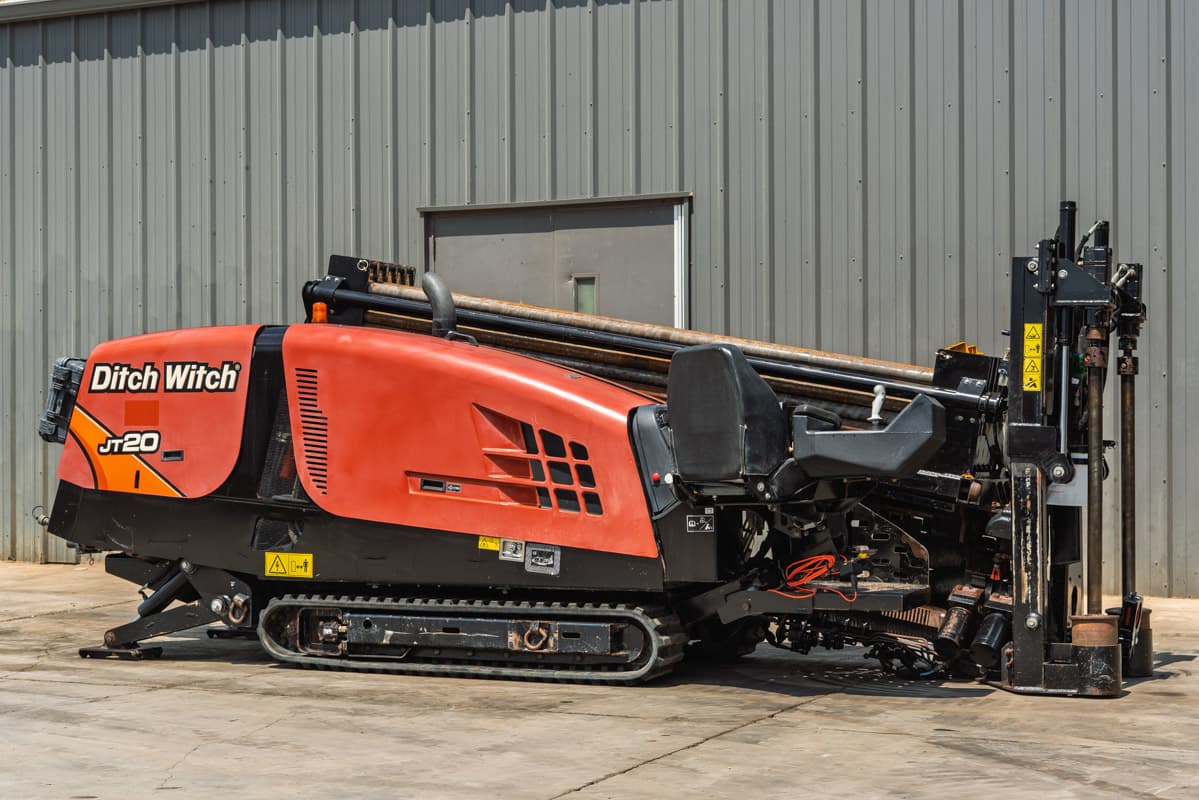 2021 Ditch Witch JT20 HDD drill, 3/4 side view, orange hood, rubber tracks, loaded drill pipe, drill frame raised