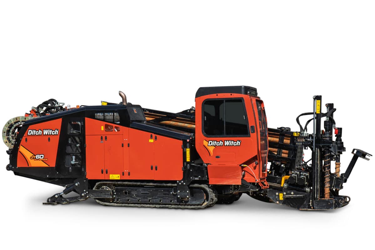 2025 Ditch Witch JT60 All Terrain HDD rig, side view, orange cab, loaded drill pipe rack, carriage, pipe loader, rubber tracks
