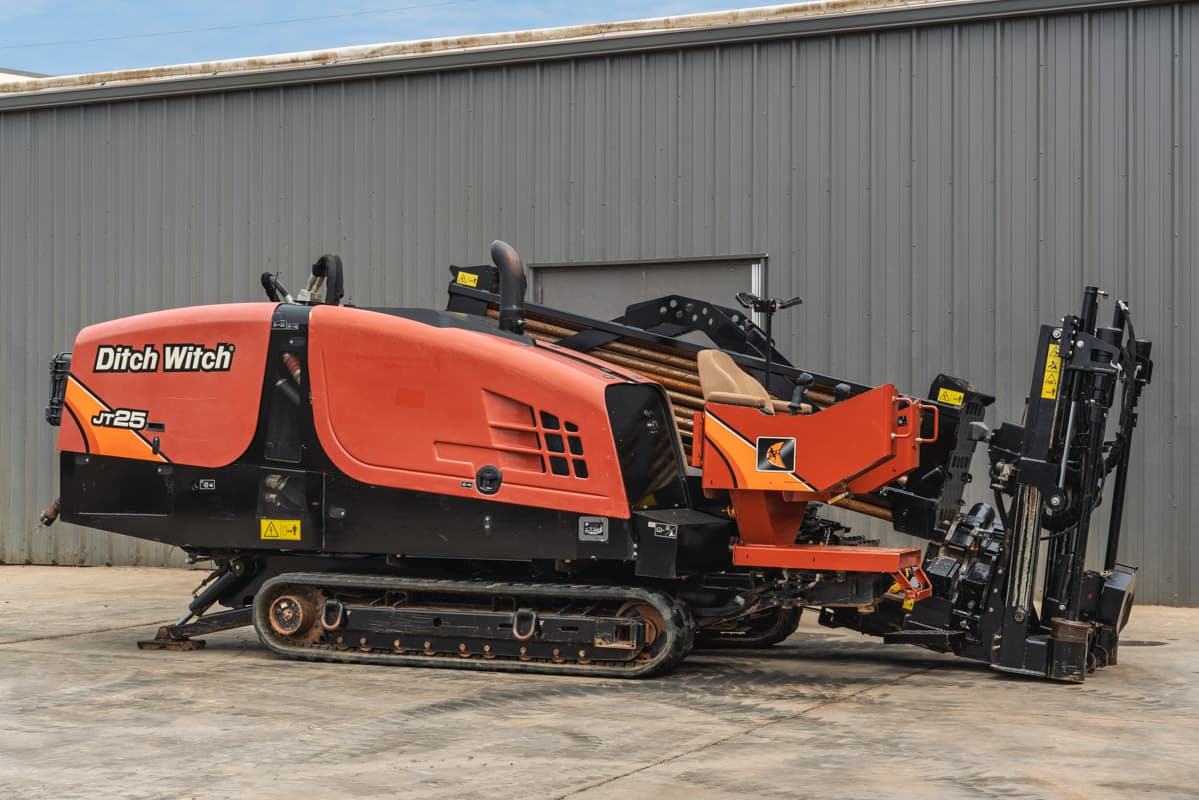 2021 Ditch Witch JT25 horizontal directional drill, side view, showing tracks, operator station, and drill pipe rack.