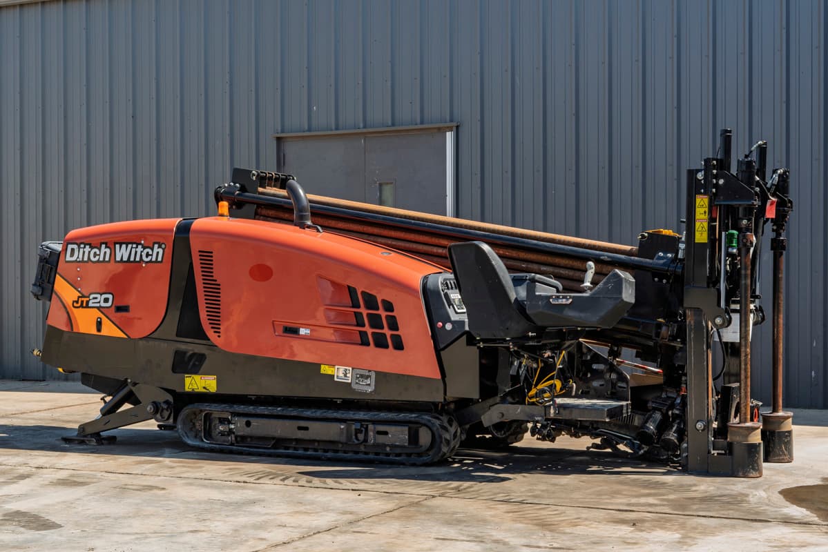 2018 Ditch Witch JT20 HDD drill, side profile view, showing tracks, operator station, drill pipe rack, and engine cowling.