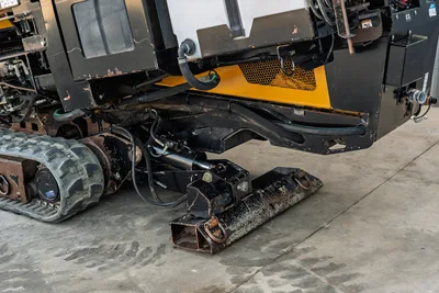 2016 Vermeer D23x30 S3 undercarriage close-up showing rubber track, hydraulic anchor system, and rear stabilizer blade with wear