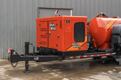 2023 Ditch Witch HX75 mud mixing unit on trailer, front-side angle, orange enclosure with HX75 decal, mixing tank visible right