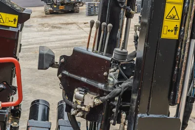 2021 Ditch Witch JT25 operator station, hydraulic control levers, safety placards, and drill pipe assembly close-up.