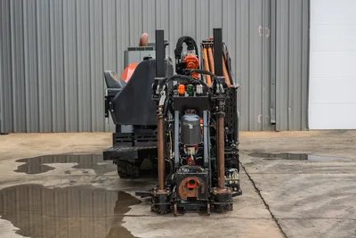 2024 Ditch Witch JT24 HDD drill, rear view showing carriage, spindle, hydraulic lines, drill pipe rack, and operator seat