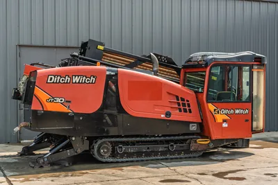 2017 Ditch Witch JT30 HDD drill, side view, rubber tracks, enclosed cab, drill pipe rack loaded, carriage assembly visible