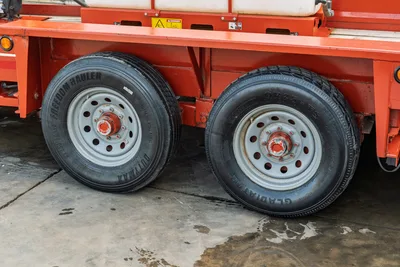 2019 Belshe WB14-2EP mud mixer trailer dual axle wheels, Freedom Hauler and Gladiator tires, orange steel frame, danger decal visible