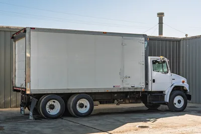 2000 Freightliner FL80 mud truck, side profile view, featuring tandem axle chassis and white Morgan dry freight van body.