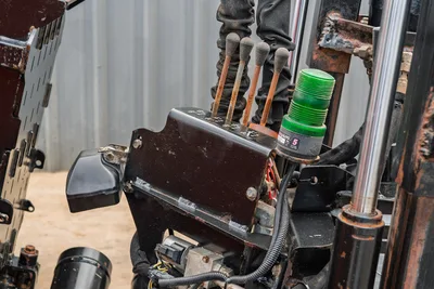 2016 Ditch Witch JT25 hydraulic control valve block with joystick levers, green beacon light, and wiring harness