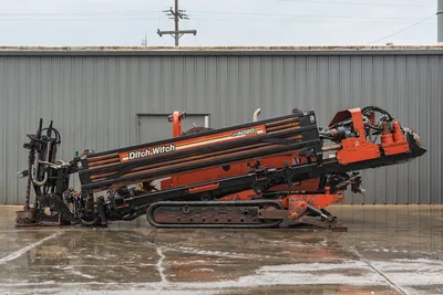 Side view of 2008 Ditch Witch JT4020 MACH 1 HDD drill with pipe rack, operator cab, steel tracks, and hydraulic components.