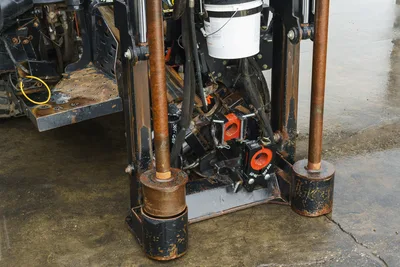 2015 Ditch Witch JT20 HDD drill frame closeup showing anchor legs, drill pipe, vise assembly, and hydraulic hoses with wear