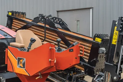 2021 Ditch Witch JT25 operator station showing drill pipe rack, joystick controls, Tan seat, and tracks side profile.