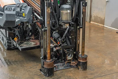 Ditch Witch JT20 rear view showing drill pipe, rotary head, hydraulic manifold, and engine compartment with operational controls