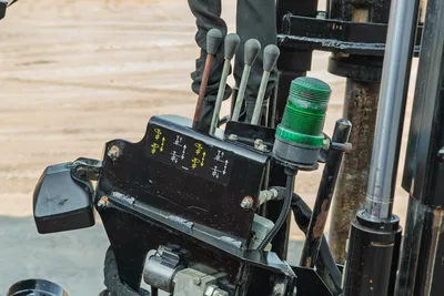 2021 Ditch Witch JT28 hydraulic control levers with labeled valve block, green beacon light, and drill frame components