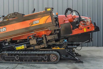 2021 Ditch Witch JT28 HDD drill, side view showing drill frame, spindle, loaded drill pipe, rubber tracks, and front anchor