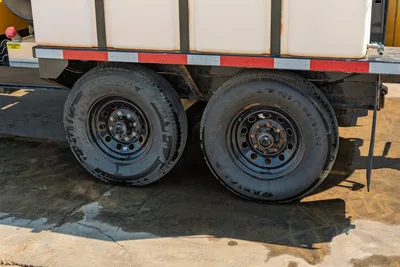 Side profile of dual-axle trailer base on 2024 Vermeer LP573SGT mud recycling system with black rims and Triangle tires.