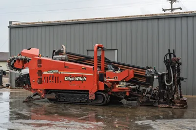 2008 Ditch Witch JT4020 MACH 1 HDD drill with rubber tracks, pipe rack, operator station, and drill string in profile view.