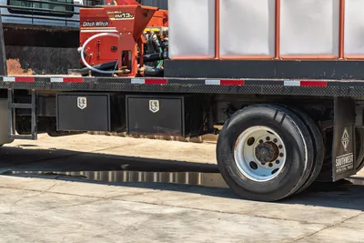 2015 International 7400 mud truck midframe, dual underbody toolboxes, rear axle, Ditch Witch FM13v mud mixer visible on flatbed