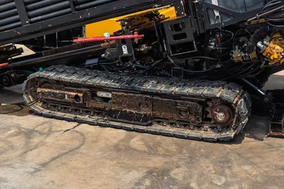 Side view of 2014 Vermeer 24x40 Series II rubber tracks, undercarriage, drill pipe rack, and hydraulic drive components.