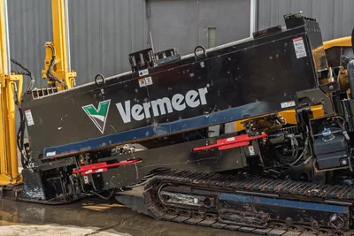 2018 Vermeer D24x40 S3 HDD rig side view showing black drill frame, Vermeer logo, red pipe rack holders, and rubber tracks