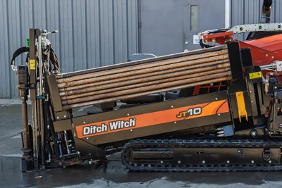 Ditch Witch JT10 horizontal directional drill with 1.66" drill pipe bundle, tracked carrier, rotary head, and pullback winch system