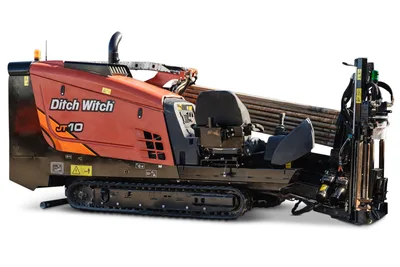 Ditch Witch JT10 HDD unit with tracked undercarriage, red/orange cab, drill pipe rack, and right-side pullback winch assembly, 66 hp, 9,000 lbs thrust capacity