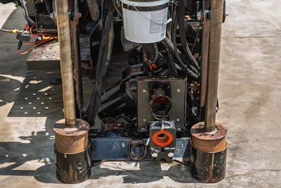 2021 Ditch Witch JT20 front end close-up showing anchor posts, vise assembly, fluid swivel, hydraulic hoses, and frame detail