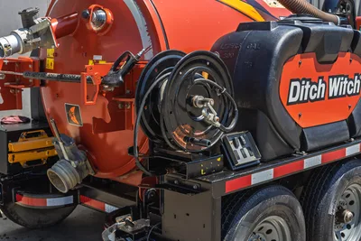 2023 Ditch Witch HX30 mud mixing unit, rear hose reel, 75-gal poly tank, trailer axle, safety decals visible, close-up side angle