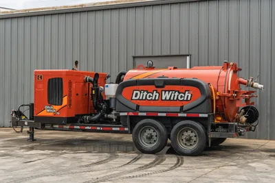 2023 Ditch Witch HX75 mud recycler on tandem-axle trailer, passenger side view, orange vacuum tank, engine enclosure, hose connections visible