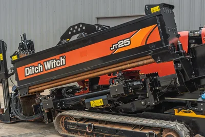 2021 Ditch Witch JT25 horizontal directional drill, side view, showing drill pipe rack, carriage, and rubber tracks.