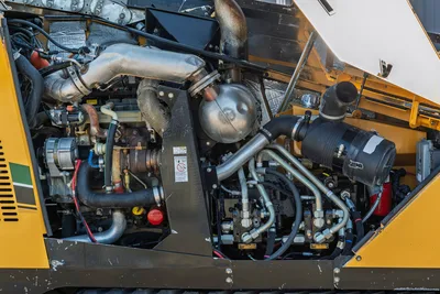 2016 Vermeer D23x30 S3 open engine compartment showing diesel engine, exhaust wrap, hydraulic manifold, and hose connections