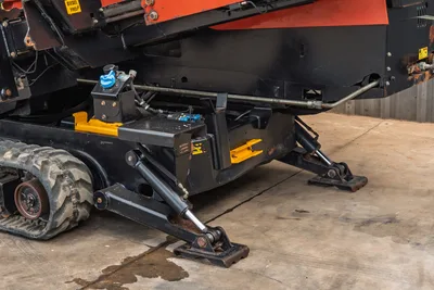 2016 Ditch Witch JT25 undercarriage detail showing rubber tracks, hydraulic anchoring system, and yellow ground anchor plates