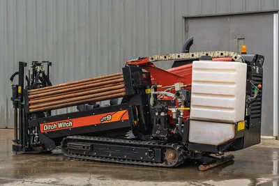 2016 Ditch Witch JT9 HDD drill, 3/4 rear view, loaded drill pipe rack, rubber tracks, fluid tank, hydraulics visible