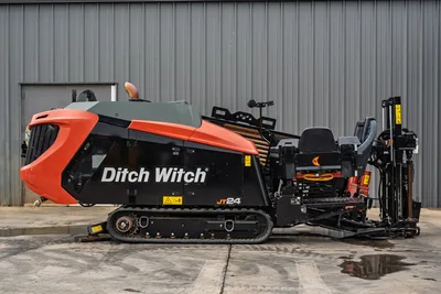 2024 Ditch Witch JT24 HDD drill, full left-side profile, rubber tracks, drill pipe rack loaded, angled carriage, operator seat visible
