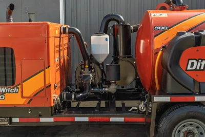 2022 Ditch Witch HX30 mud recycler pump compartment, side view showing mixing hopper, plumbing, filters, and 500-gal tank
