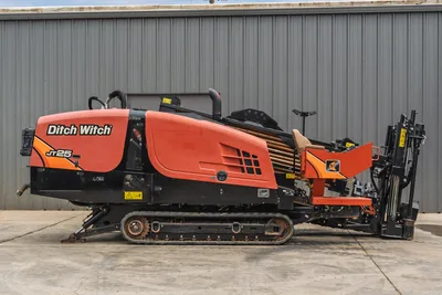 Side view of 2021 Ditch Witch JT25 HDD drill featuring steel tracks, engine cowling, operator station, and drill pipe rack.