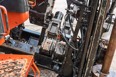 2021 Ditch Witch JT28 carriage and spindle assembly, overhead view showing hydraulic lines, vise jaws, and wear-worn drill frame components