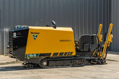 Vermeer D10x15 Navigator HDD rig, side view, yellow and black tracked unit with drill pipe, pullback arms, 10,000 lbs thrust capacity