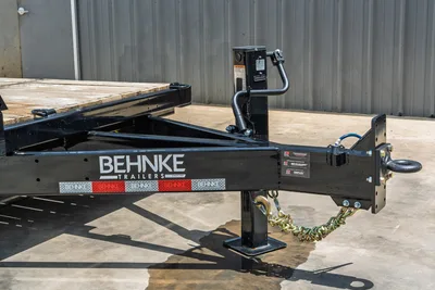 Behnke TBCT2220ET-BT-R trailer tongue closeup showing jack, coupler, safety chains, Dexter Torflex axle tags, and diamond-plate decals