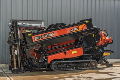 2017 Ditch Witch JT30 HDD drill, side view, drill frame elevated, rubber tracks, vise assembly, drill pipe loaded, red/black livery