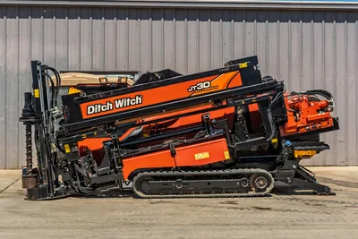 Profile view of 2016 Ditch Witch JT30 All Terrain HDD rig, showing tracks, drill stem, and orange drill carriage.