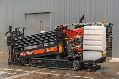 2018 Ditch Witch JT10 HDD drill, side profile view showing integrated drill pipe rack, rubber tracks, and fluid tank.