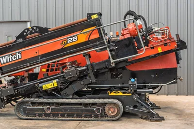 2021 Ditch Witch JT28 HDD drill, side profile, elevated drill frame, red spindle, hydraulic lines, rubber tracks, anchor system visible