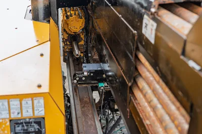2016 Vermeer D23x30 S3 drill frame close-up showing spindle, hydraulic rotary drive, carriage rail, and stacked 2.375" drill pipe