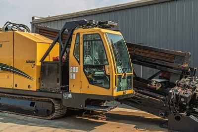 2017 Vermeer D100x140 S3 Navigator HDD rig, operator cab close-up, loaded drill pipe rack, steel tracks visible
