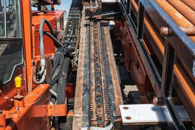 2014 Ditch Witch JT100 Mach 1 drill frame rack and pinion thrust system, worn hydraulic hoses, pipe rack with used 3.5" drill pipe