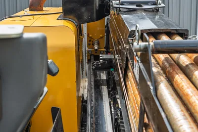 2024 Vermeer D20x22 S3 drill frame close-up showing rack-and-pinion carriage, spindle, hydraulic lines, and loaded drill pipe rack