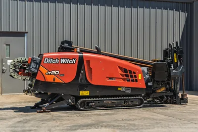 Side profile of 2021 Ditch Witch JT20 HDD drill with rubber tracks, engine cowling, drill pipe rack, and operator seat.