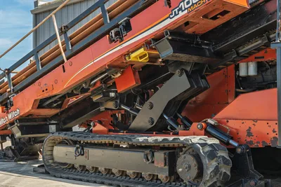 2014 Ditch Witch JT100 Mach 1 rubber tracks, angle frame, hydraulic cylinders, drill pipe rack, worn paint, low-angle side view