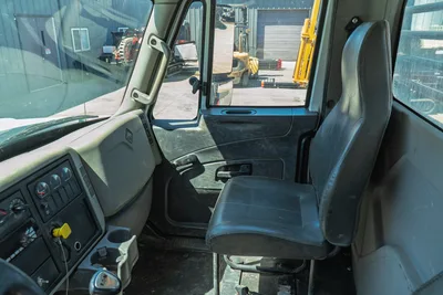 2015 International 7400 mud truck cab interior showing black vinyl passenger seat, dashboard, gauges, and Eaton transmission shifter